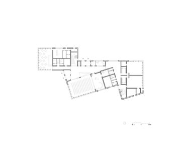 Architektonischer Grundriss des Erdgeschosses mit zentralem großen Raum, vermutlich Saal oder Aula, sowie angrenzenden kleineren Räumen und Fluren. Treppen und Eingangsbereiche sind erkennbar. – Klicken zum Vergrößern